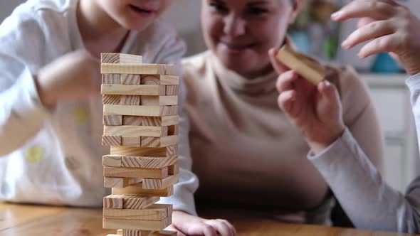 Children together with parents build tower out of wooden cubes