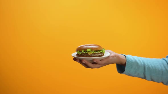 Female Showing Refuse Gesture to Burger on Plate, Fast Food Restriction, Diet