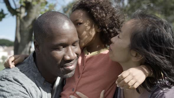 Lovely Little Girl Kissing and Hugging Parents in Park