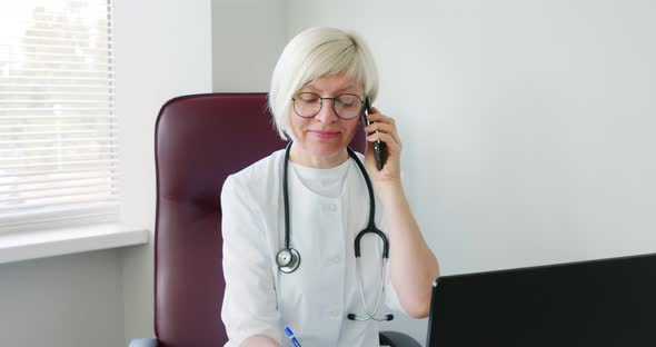 Female doctor consulting patient using phone call, listening