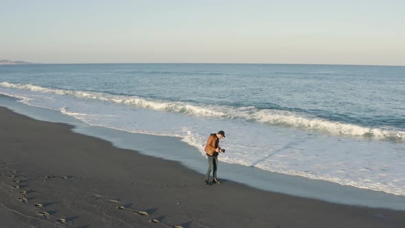 Aerial view of a photographer by the ocean