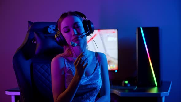 Tattooed Gamer Girl Sitting By the PC and Sucking a Lollipop