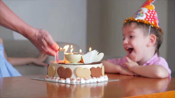 Happy Kids Little Boy and His Little Sister Watch Dad Light the Candles on the Cake on Their