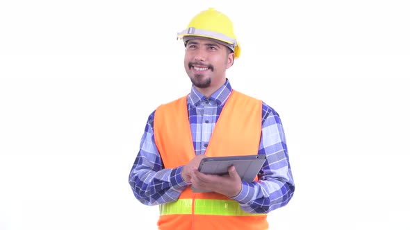 Happy Bearded Persian Man Construction Worker Thinking While Using Digital Tablet