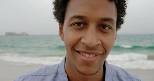 Front view of African American man standing on the beach 4k