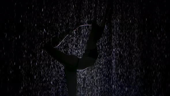 Dancer Pose in the Pouring Rain. Wet Body Silhouette of Young Woman Practicing Yoga Exercises in