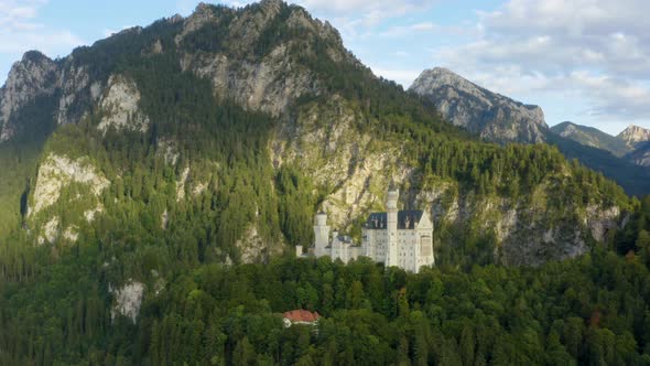 Aerial circle shot of Neuschwanstein Castle, Germany, golden hour