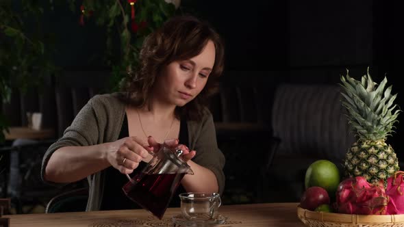 Beautiful Girl Pours Herself Red Tea