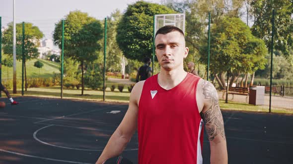 Closeup Portrait of Young Fashionable and Attractive Basketball Player in Red Jersey with Ball in