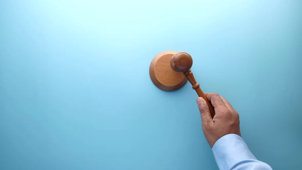 Top View of Person's Hand Striking the Gavel.