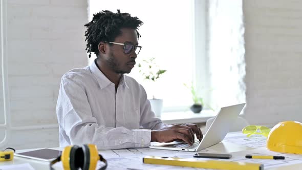 African Engineer Smiling at Camera in Office 