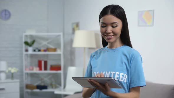 Cheerful Volunteer With Tablet Smiling Camera, Online Fundraising Application