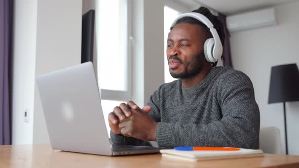 Smiling Young Man Watching Video Tutorial While Sitting on Isolation Indoor