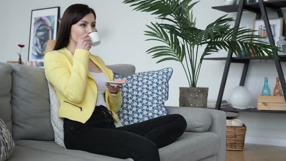 Woman Drinking Coffee While Sitting on Sofa