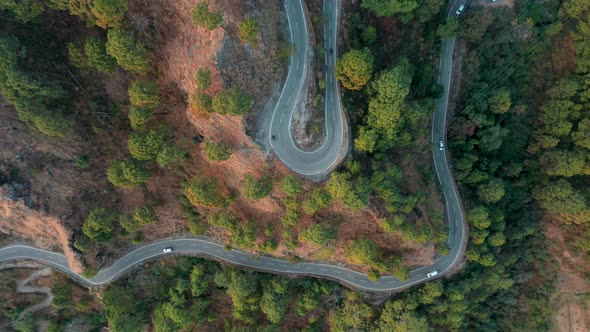 Aerial view of vehicles driving a mountain road in Manali, India.