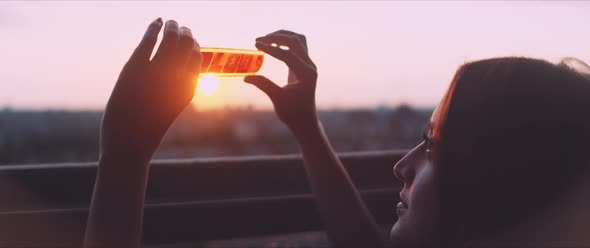 Woman photographer observing the film strip during sunset