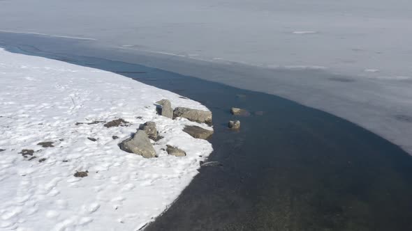 Coastal area and frozen water of lake by winter 4K drone video