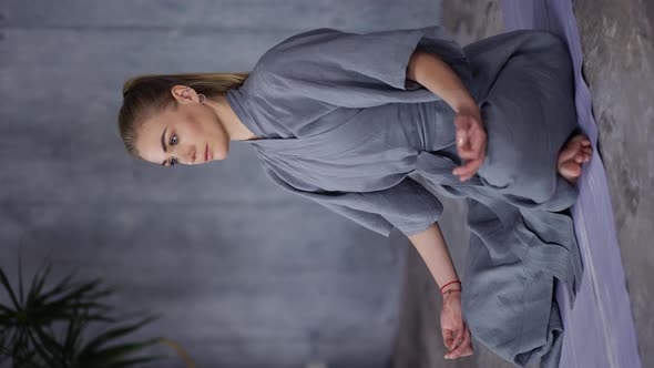 Elegant Woman in Stylish Blue Robe Sitting in Lotus Pose