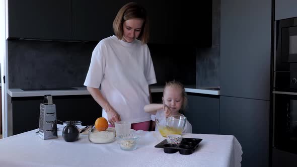 Happy Mother and Daughter Preparing Cupcakes in Kitchen