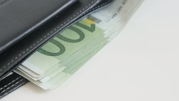 Money in black leather wallet 3840X2160 UltraHD tilting footage - Banknotes of Euro in bi-fold money