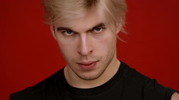 Close Up Portrait of Angry Caucasian Man Looking Sullenly at Camera Posing Over White Studio