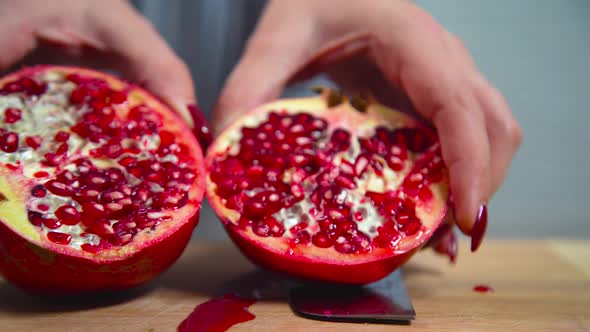 Women cuts a pomegranate with a knife