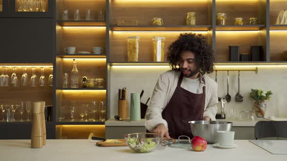 Egyptian Chef Dances Sprinkling Salad with Spices in Kitchen
