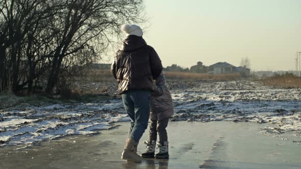 Young Woman with a Daughter of 78 Years Old Glide Merrily on the Ice of a Frozen Lake