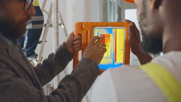 Back View of Professional Construction Team Using Infrared Camera on Tablet Checking Heating System