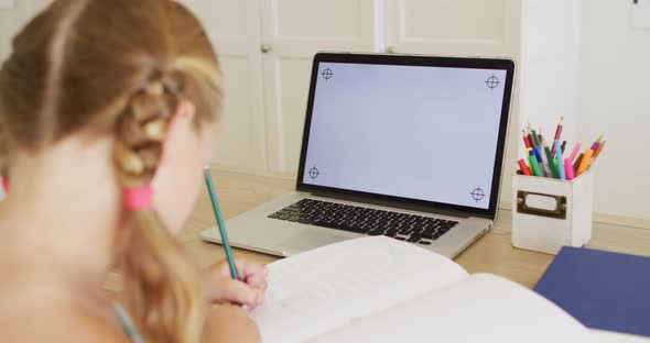 Caucasian girl having a video call on laptop with copy space while doing homework at home