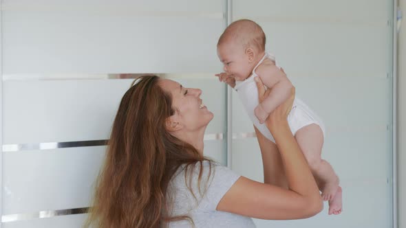 Close Up Mother Kissing Happy Baby Laughing Enjoying Loving Mom Nurturing Toddler at Home.