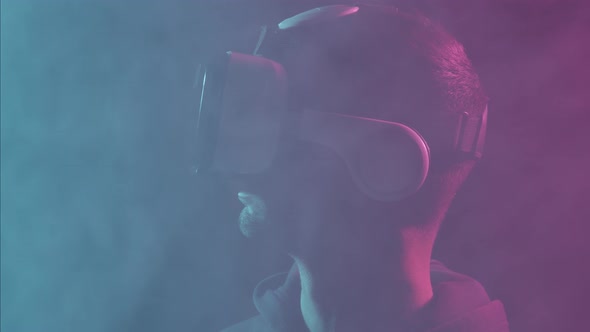 Portrait of a man in virtual reality helmet. Obscured dark face in VR goggles.