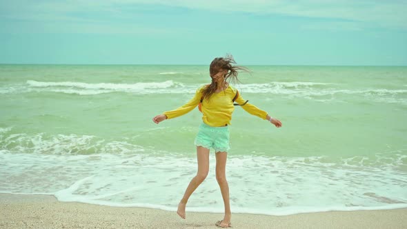 Woman Enjoing Walking Sandy Beach at Windy Stormy Day Waving Sea