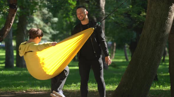 Boy pushing girl in hammock