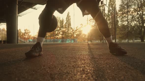 Street Basketball Player Taps the Ball on the Court