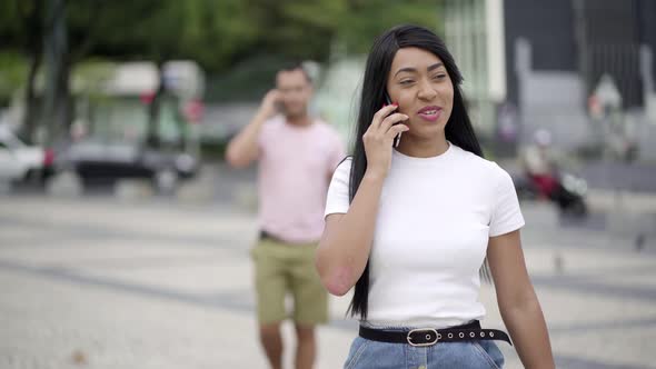 Front View of Smiling Young Woman Talking on Smartphone 