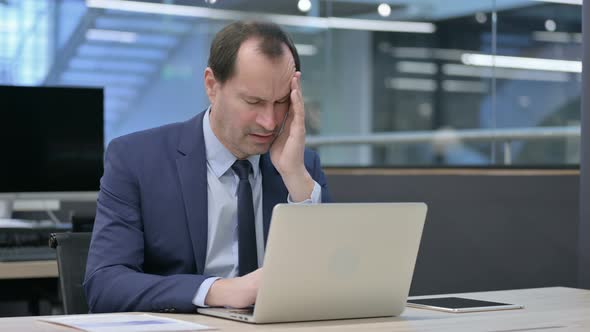 Businessman Having Headache While Working on Laptop