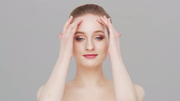 Studio portrait of young, beautiful and natural woman over grey background.