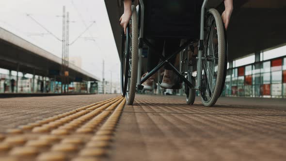 Low Angle, Young Woman Spinning the Wheels of the Wheelchair on the Train Station