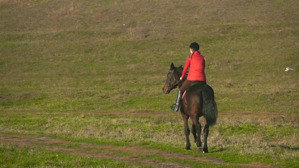 Rider Galloping on a Green Field on Horseback