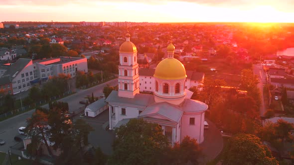 Small Church at the Bright Cloudy Sunset Filmed By Drone in Small European City. Kyiv Region