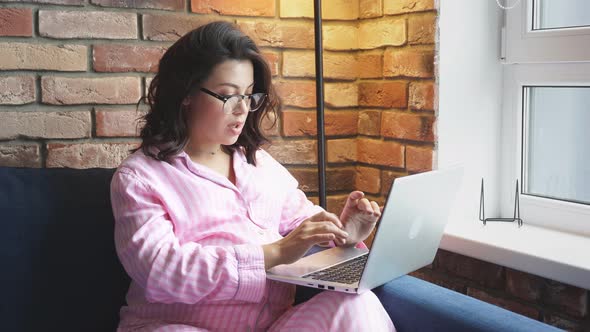 Happy Pregnant Woman Typing Something on Laptop at Home.