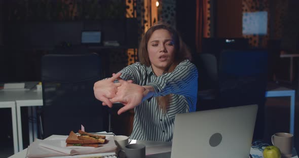 Sleepy Businesswoman Sitting at Desk in Dark Office at Night and Using Laptop, Girl Office Worker