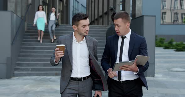 Businessman Discussing Something and Disputing with Businessman with Tablet Computer in Hands