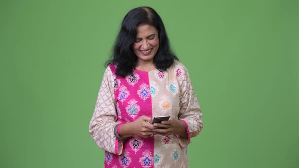 Mature Happy Beautiful Indian Woman Smiling While Using Phone