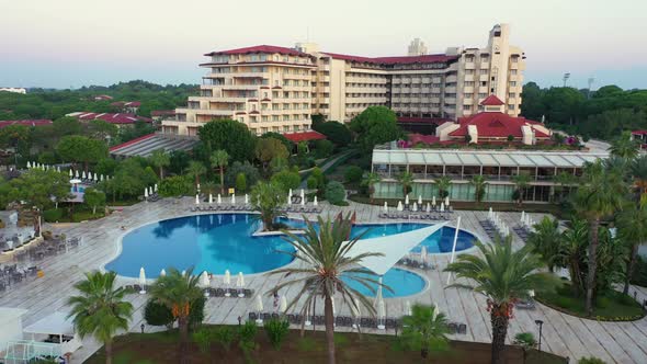 View of Hotel with Swimming Pools and Palm Trees.