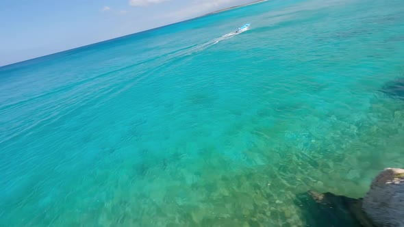 Spectacular fpv flight along tropical coastline of Caribbean Sea with cruising speedboat at summer