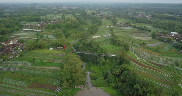 Aerial drone view of suspension bridge, valley and river with waterfalls. mangunsuko bridge or Jokow