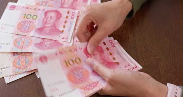 Woman counting RMB banknote