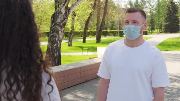 Man and Woman Having Conversation Outdoors during Pandemic